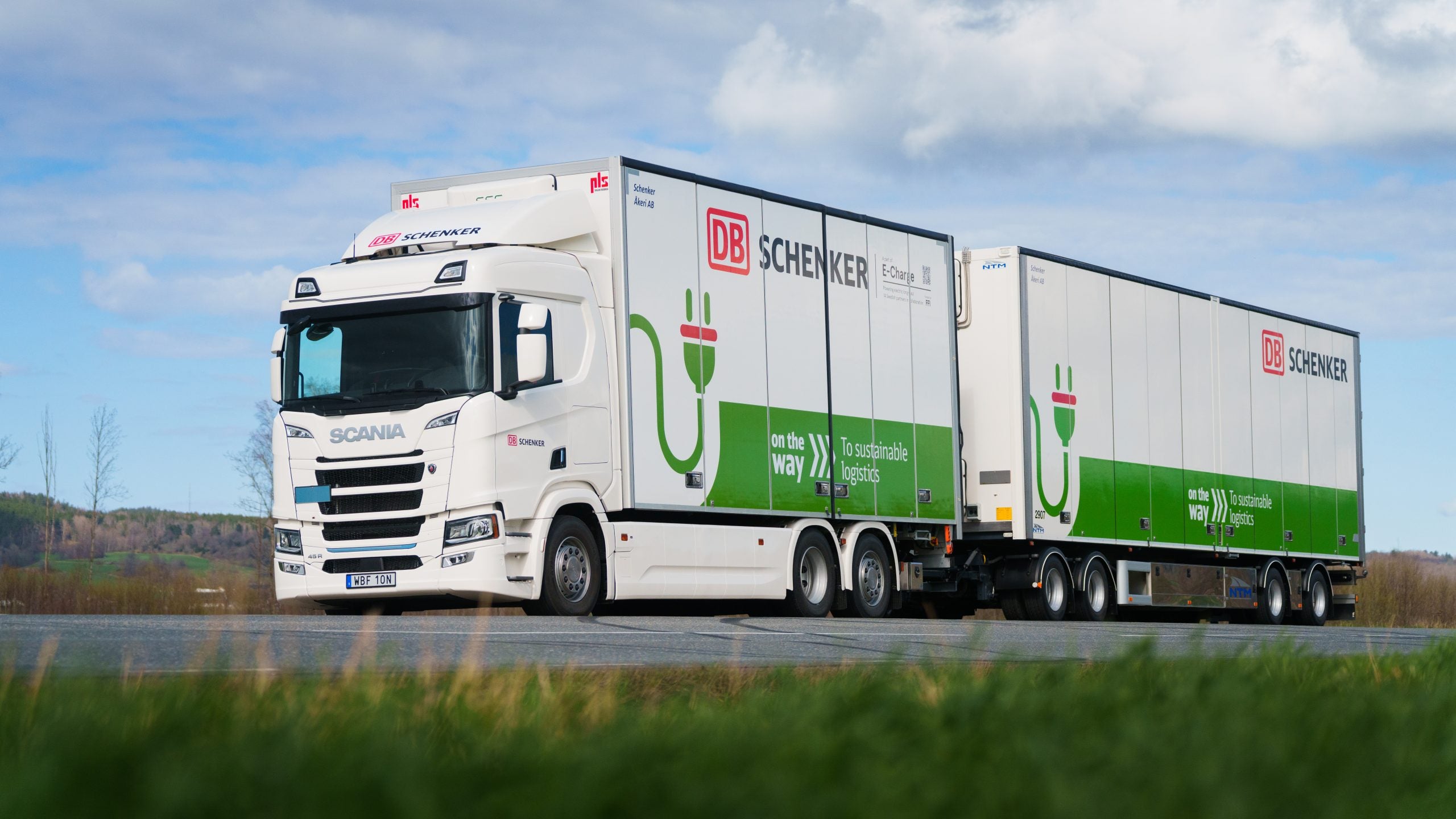 Bild på ett eldrivet Scania-fordon i samarbete med DB Schenker, som används för hållbar transport och elektrifiering inom logistikbranschen.